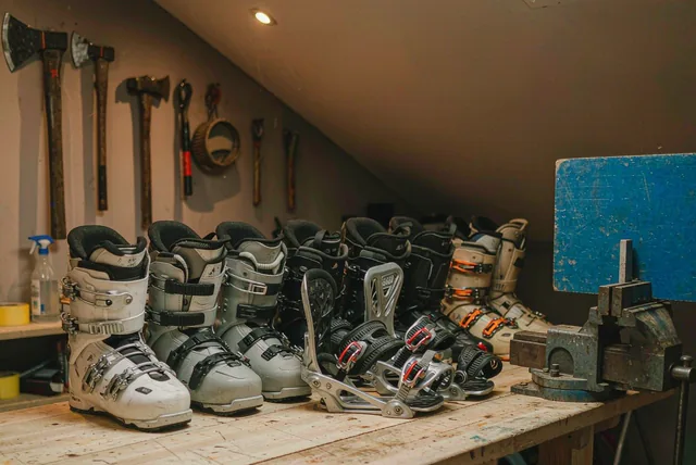 Snowboard boots and bindings lined up on a workshop bench