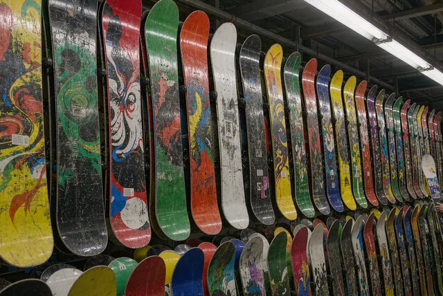Rows of snowboards stacked on racks inside a mountain rental shop